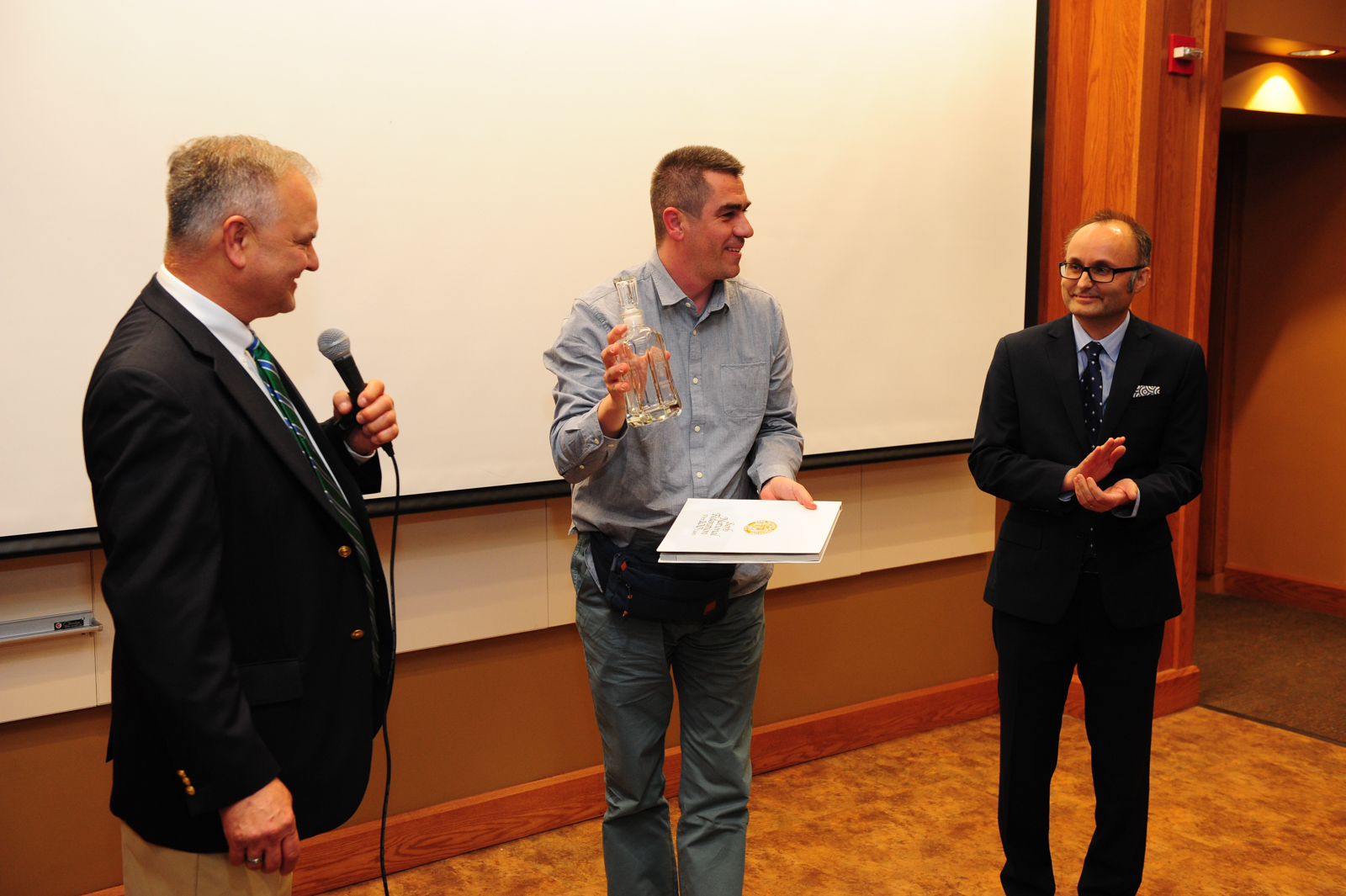 Award Ceremony (from left to right): John Martich, the President of the SNF, Zeljko Mirkovic with the “SNF Spirit Award,” the Movie Director of the “Tesla Nation,” and Milos Rastovic, the Cultural Outreach Coordinator of the SNF and Master of Ceremon